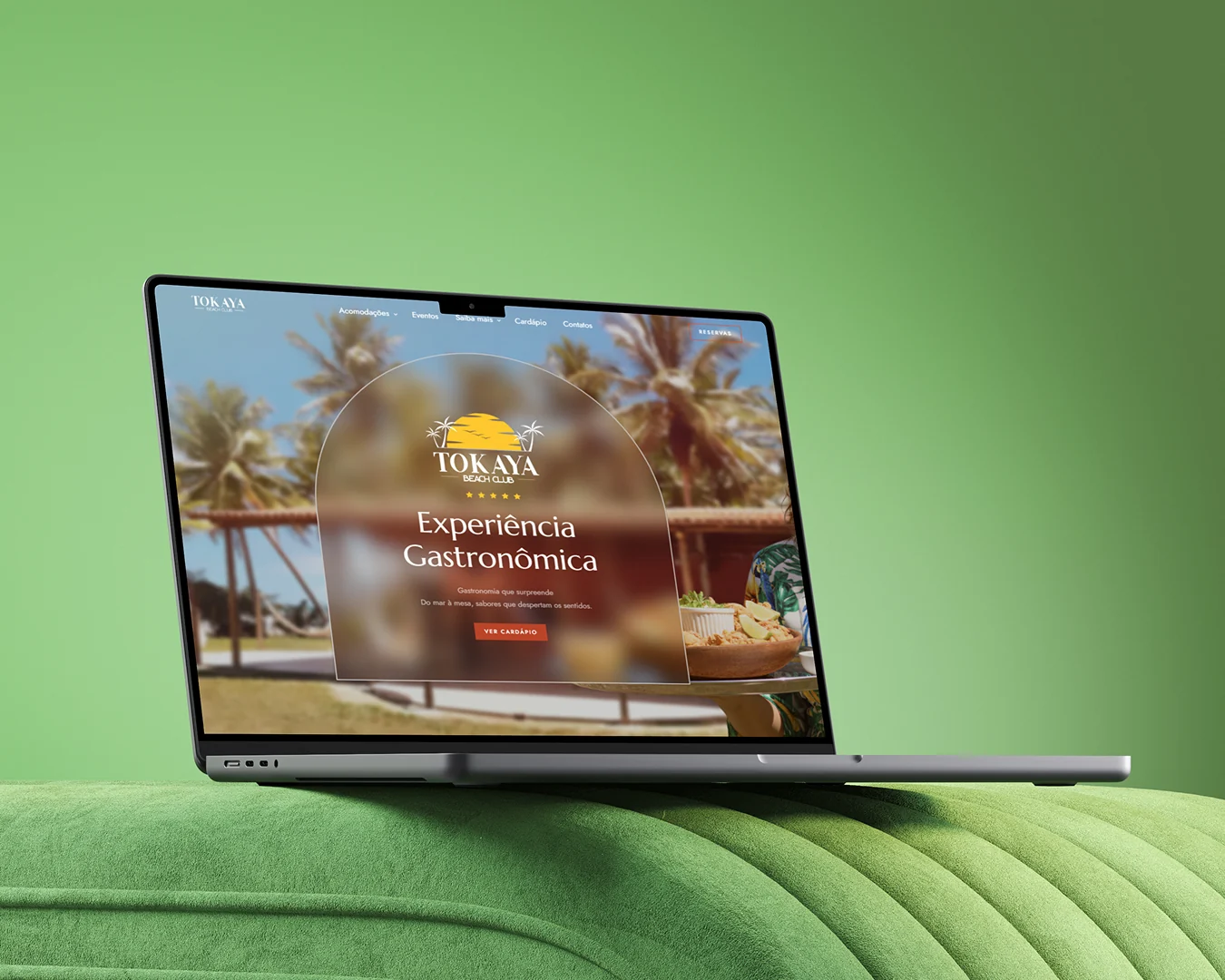 Site do Tokaya Beach Club apresentado em notebook sobre cenário verde